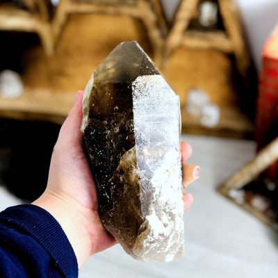 smokey quartz semi-polished point in hand for size reference