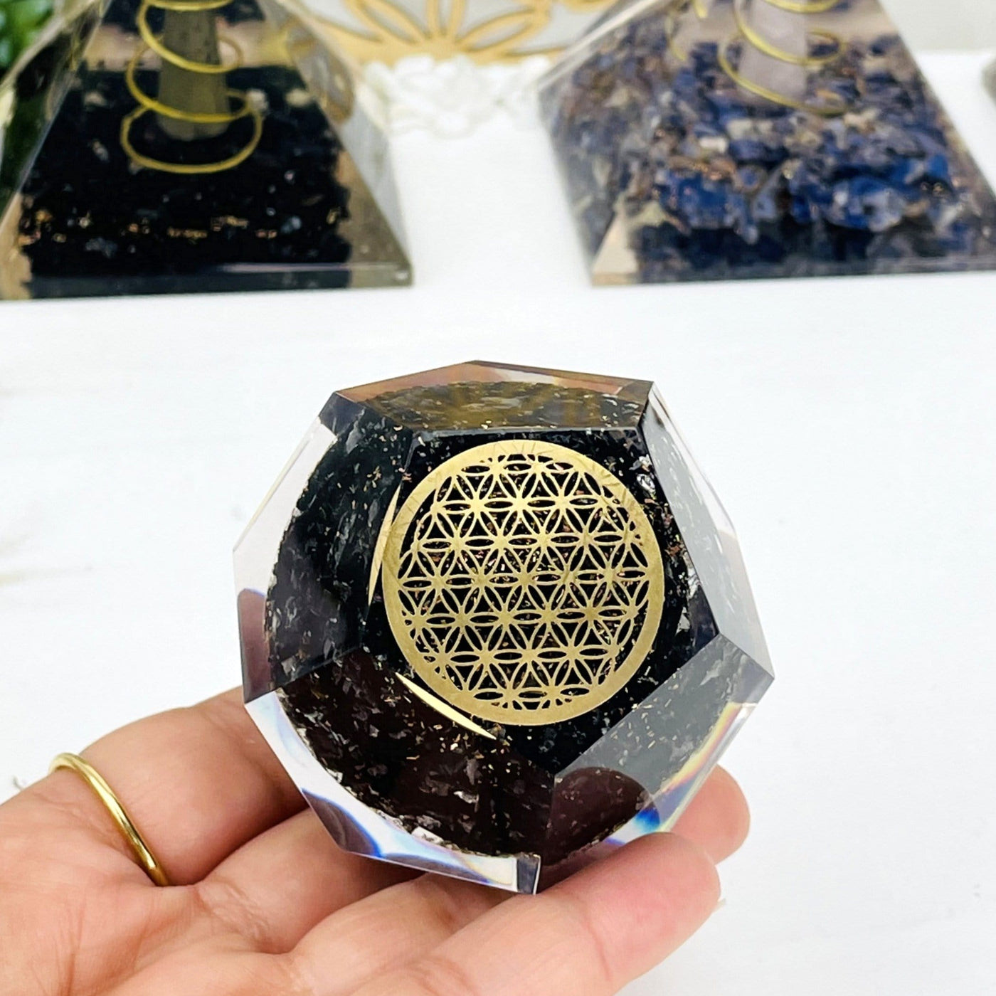 orgone tourmaline displayed in hand for size reference