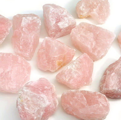 A picture with 11 pieces of rose quartz chunks