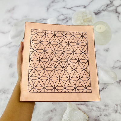 Copper Charging Dish with Flower of life grid engraved  held by hand for size comparison