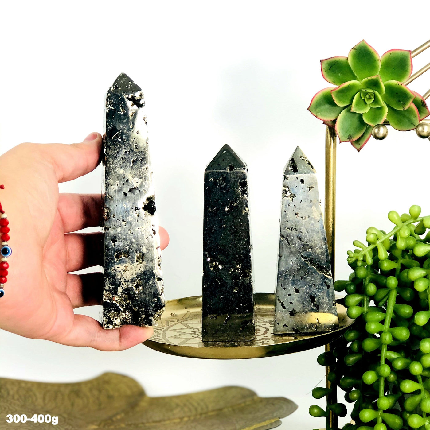 3 assorted obelisk towers in teh 300-400 gram size and one is in a woman's hand.