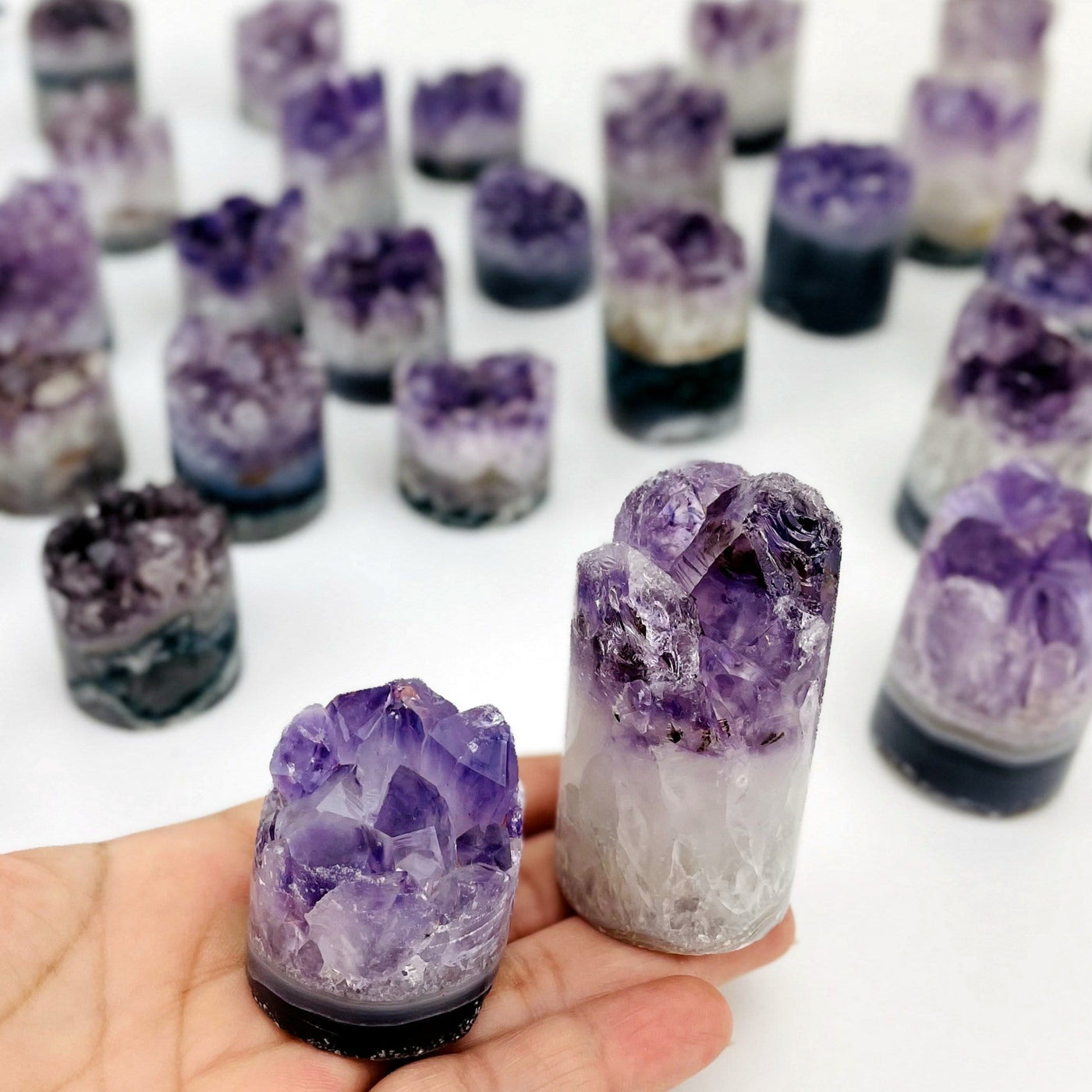 Amethyst cores with shades of white and purple in assorted sizes to show variations on a white background.