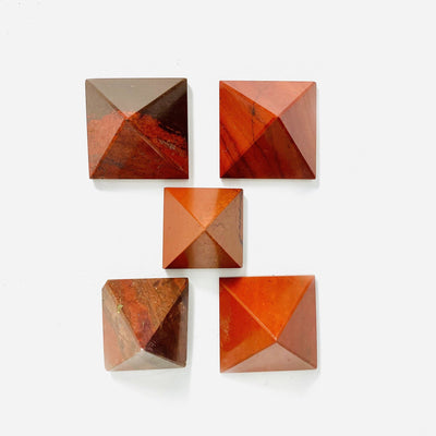 5 Red Jasper Pyramids of different sizes on white background