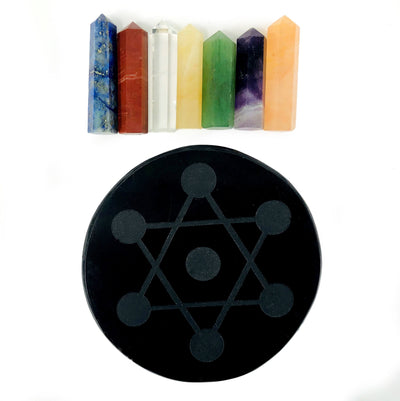 Black obsidian round disk with all seven stone points on it Amethyst, Crystal Quartz, Lapiz Lazuli, Green Aventurine, Peach Aventurine, Yellow Aventurine, and Red Jasper in a row on a white background with the obsidian disk on it's own showing it has a metratron grid engraved on it.