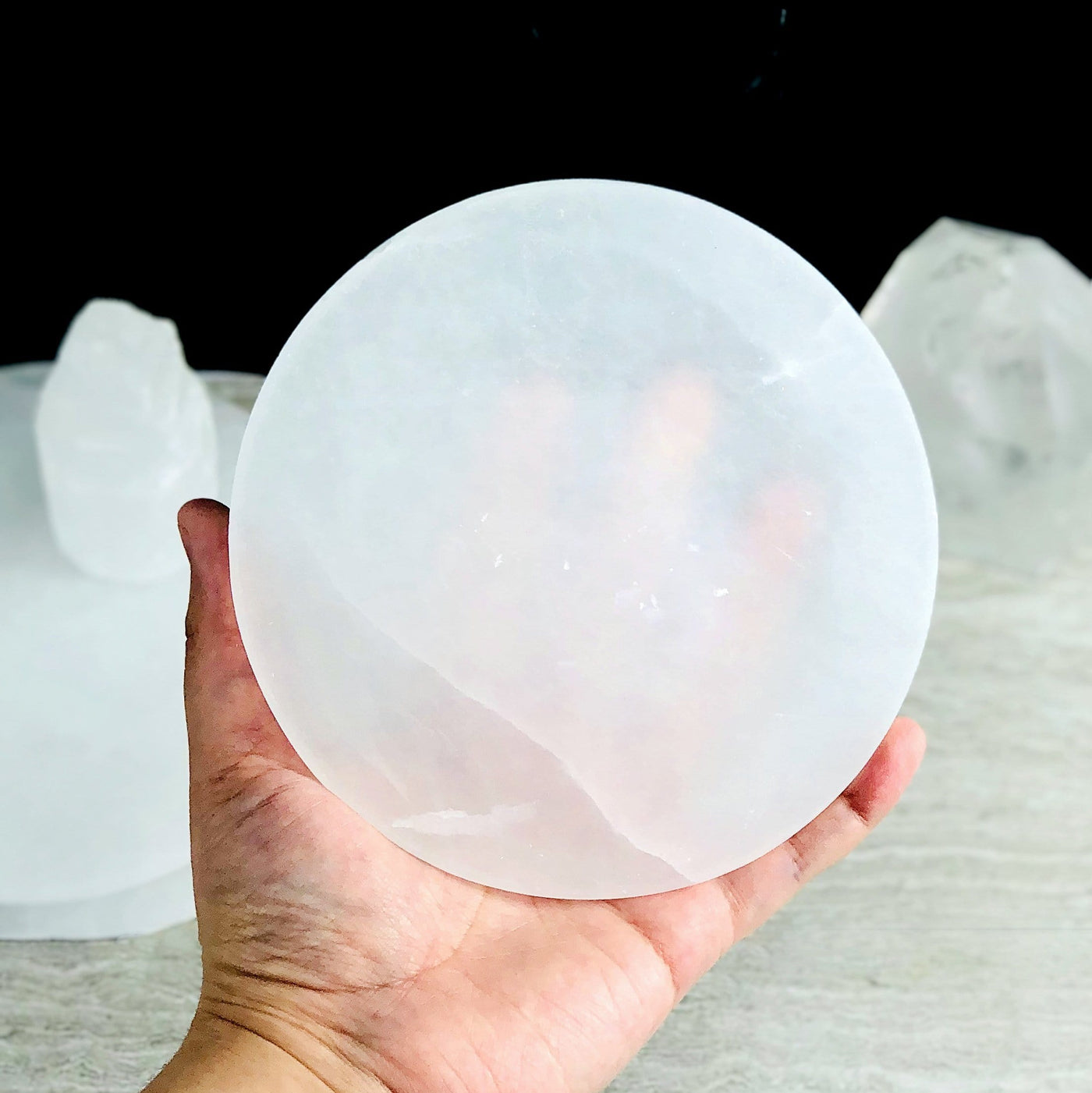 15cm round selenite charging plate in hand for size reference