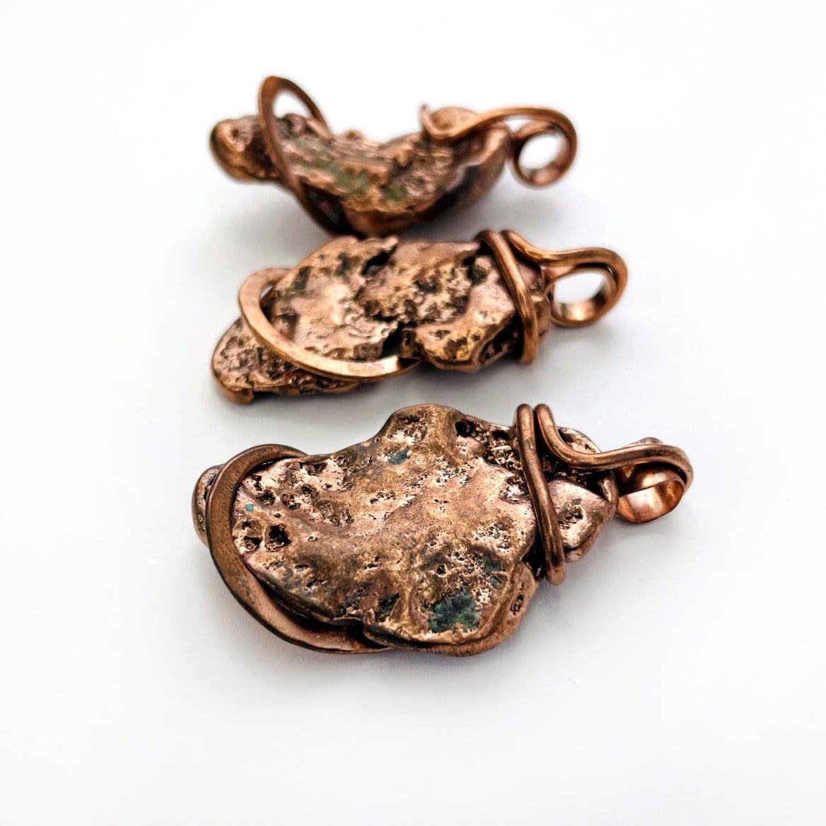 3 Copper Nugget freeform pendants from angle showing thickness and details