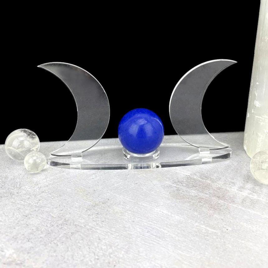 A front view of an Acrylic Sphere Holder Crescent Moons - Clear Base in an alter with acrylic moons facing outwards.