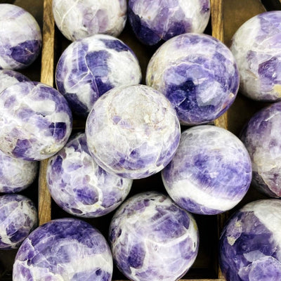 Up close view of Chevron Amethyst Polished Spheres in a wooden case.