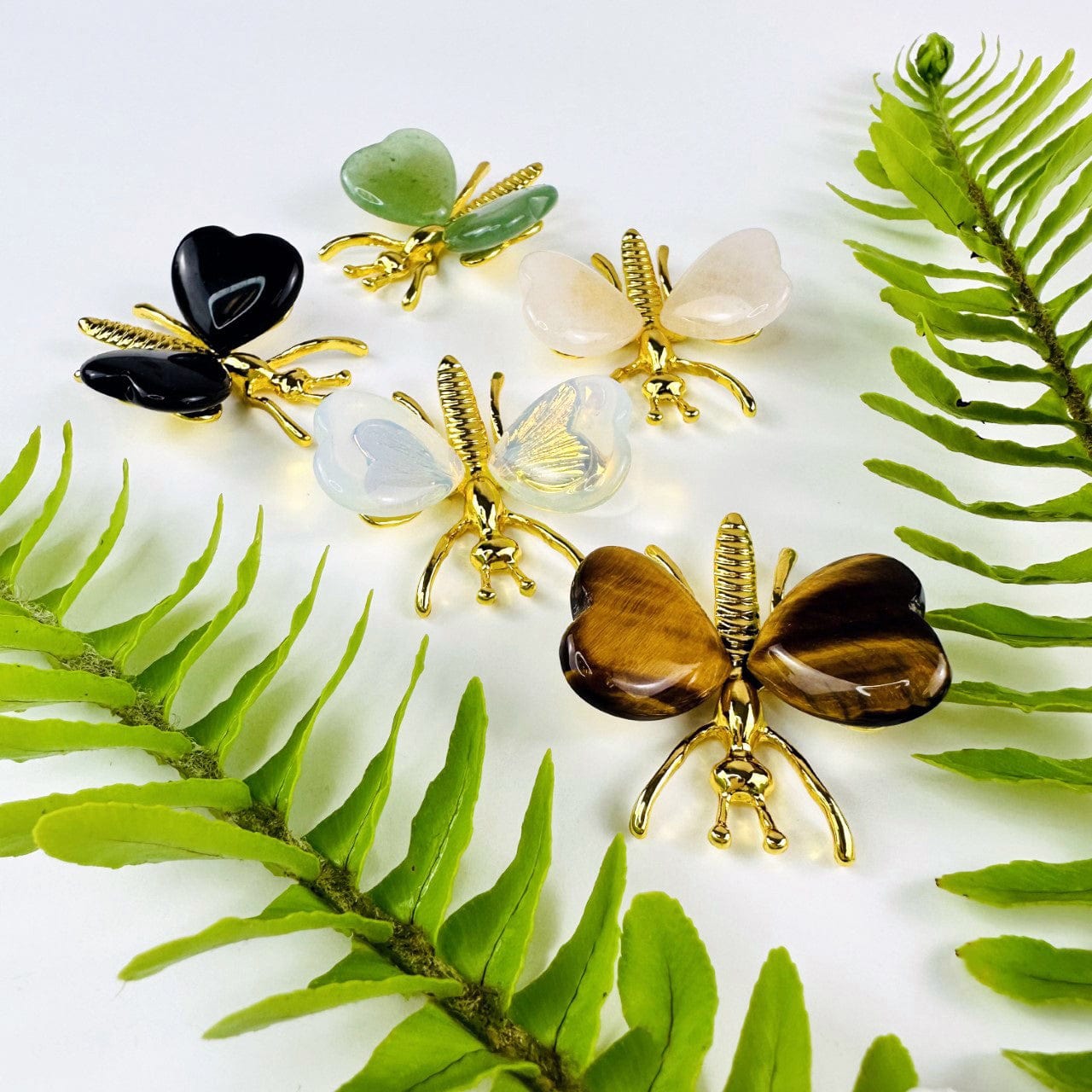Gemstone Butterflies with Gold Tone Body on a table showing the assorted stones we carry from a side angle