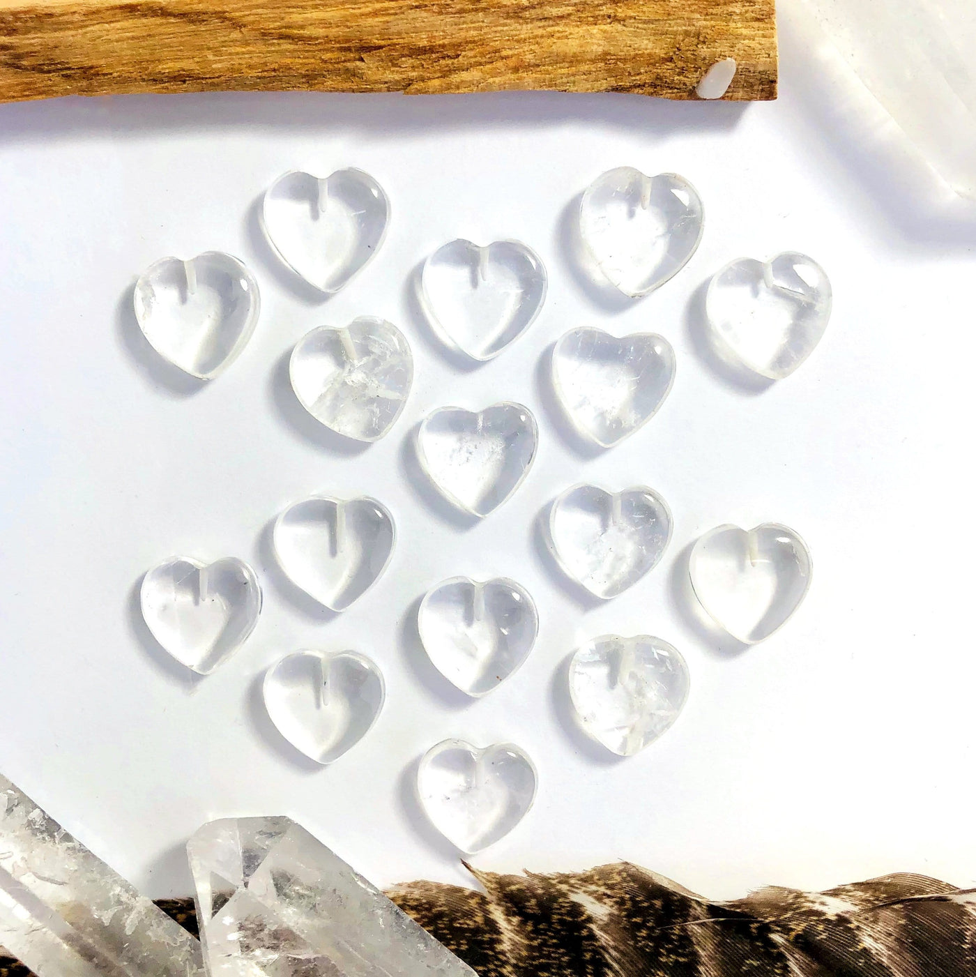 Multiple crystal quartz hearts displayed to show differences sizes and shades of quartz