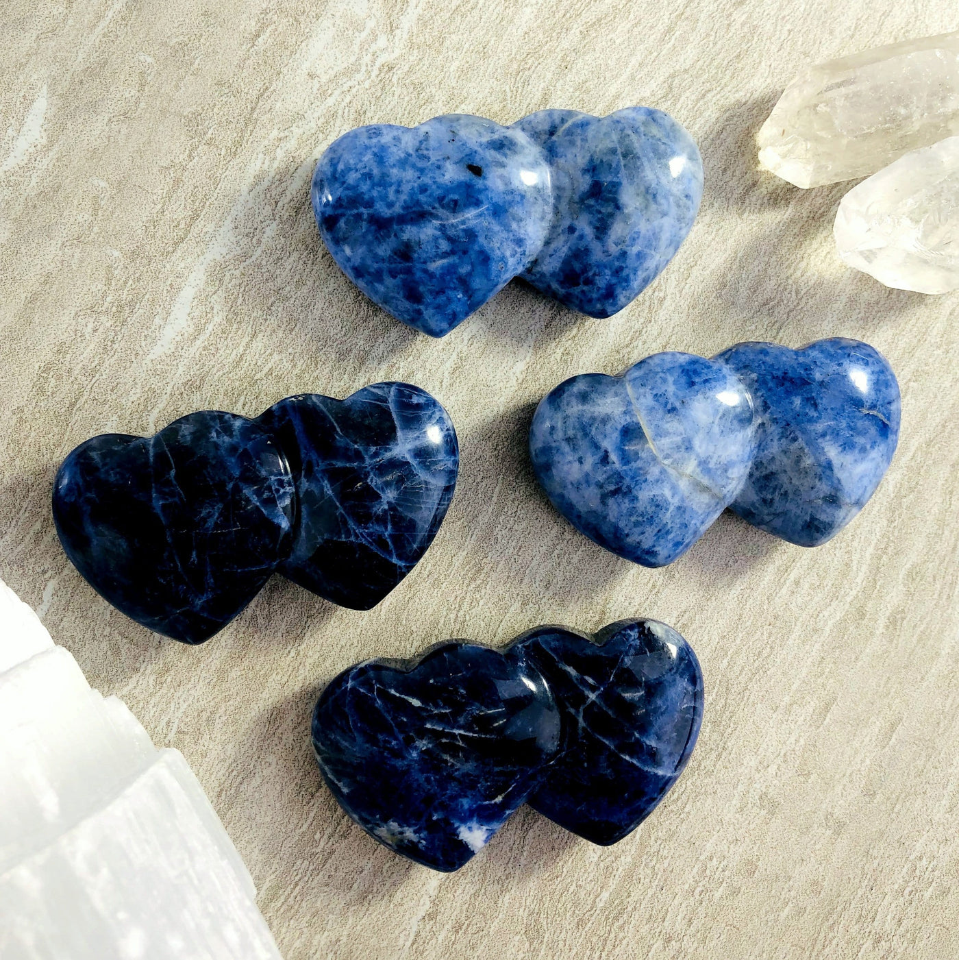 overhead view of four sodalite double heart shaped stones on display for possible variations