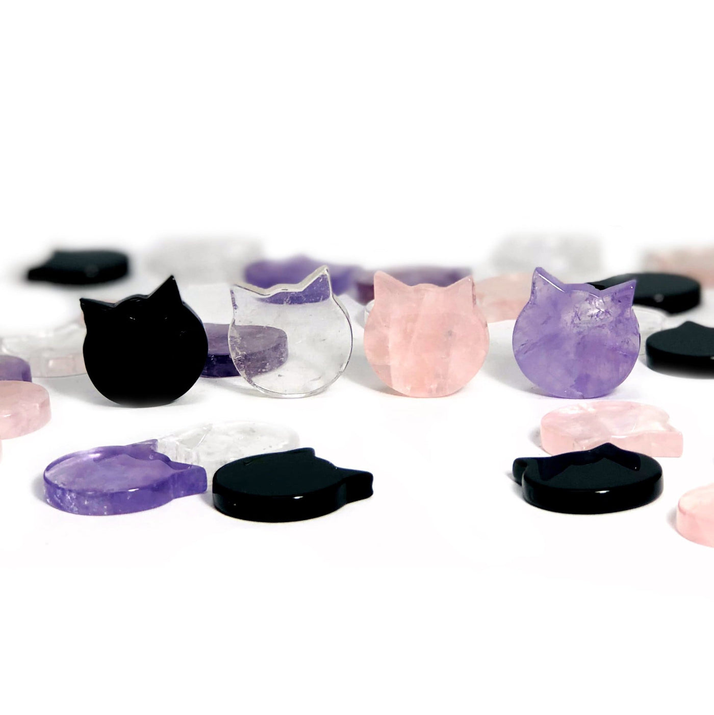 Gemstone Cats in obsidian. crystal quartz, rose quartz, and amethyst with others in the background