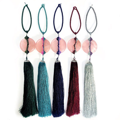 5 Rose Quartz Tassels of different colors on white background