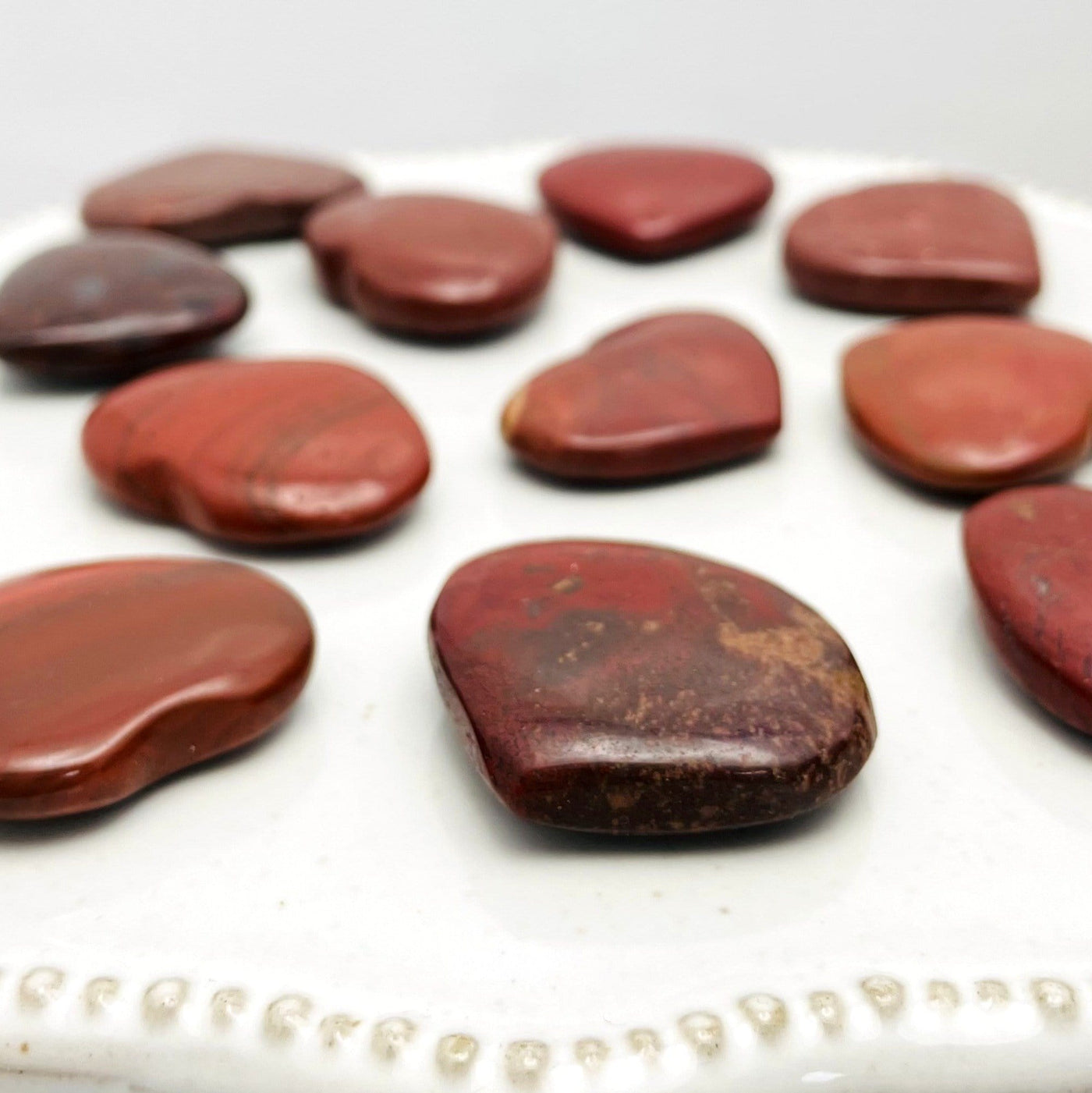 Side view of Red Jasper Heart Shaped Stones on white background