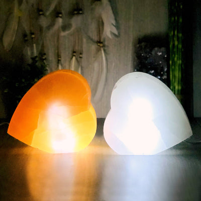 orange and white selenite heart shaped lamps lit up in the dark