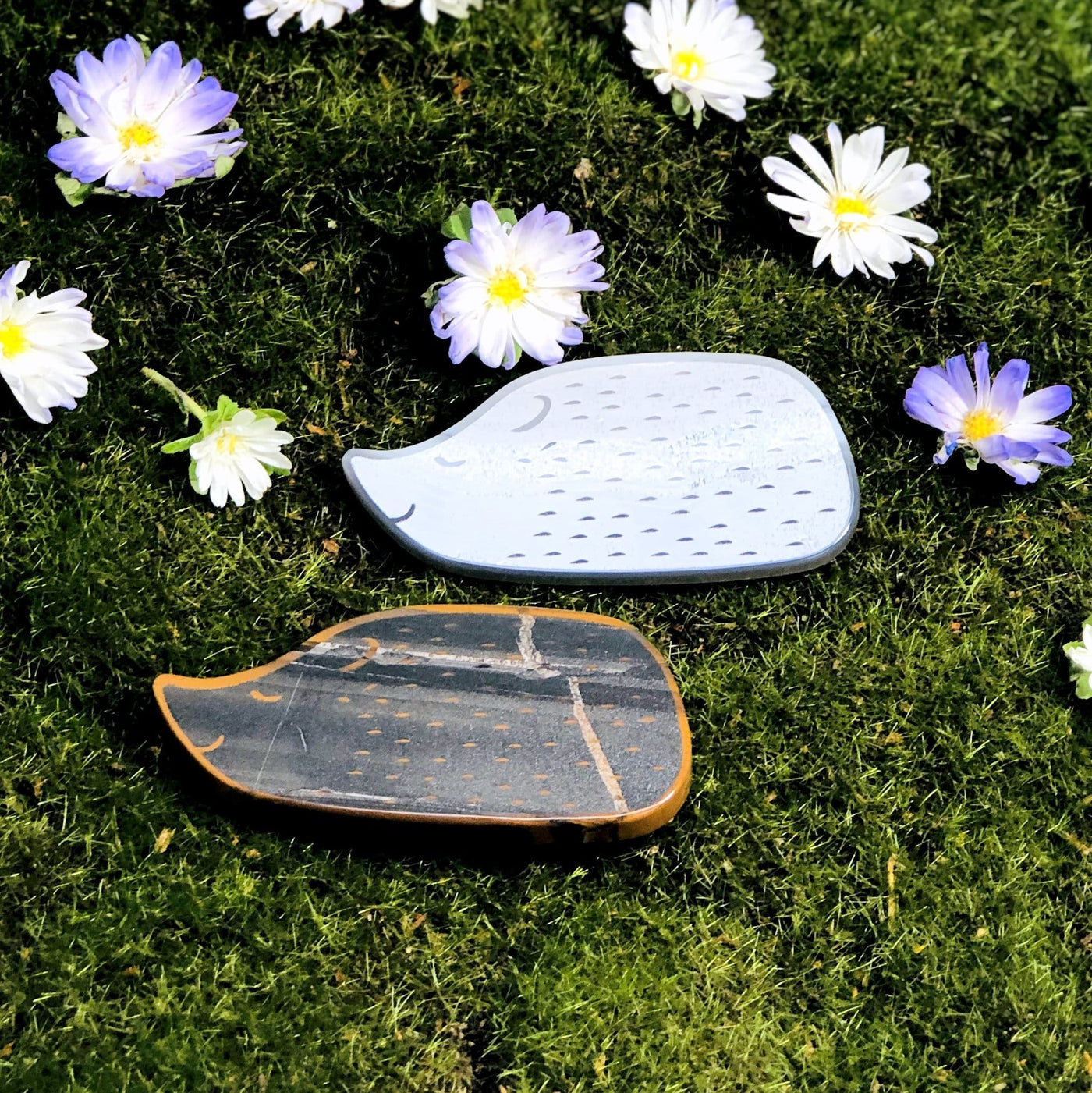 natural and black onyx hedge hog gemstone slices next to one another to show design difference