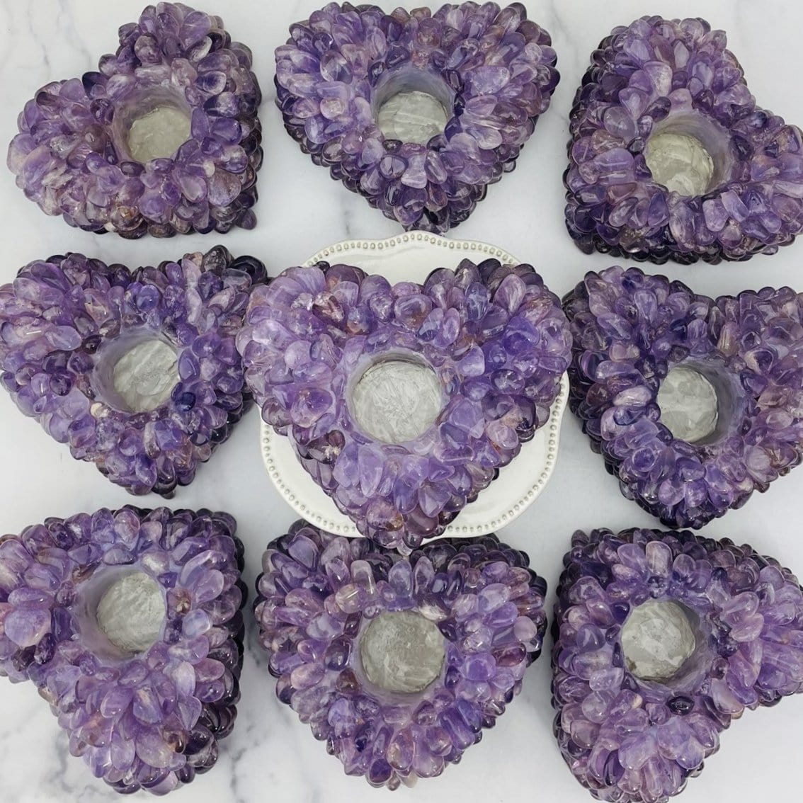 9 amethyst tumbled stone heart candle holders on marble background