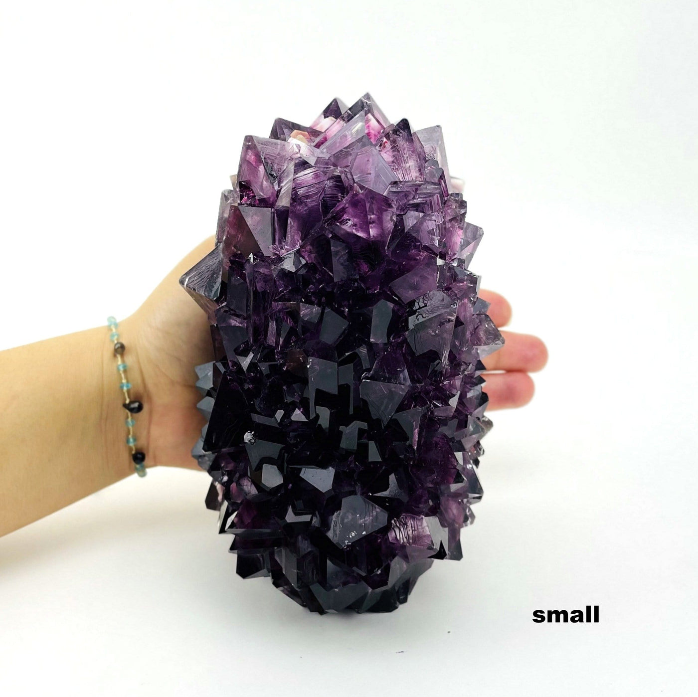 small purple salt crystal formation in hand for size reference