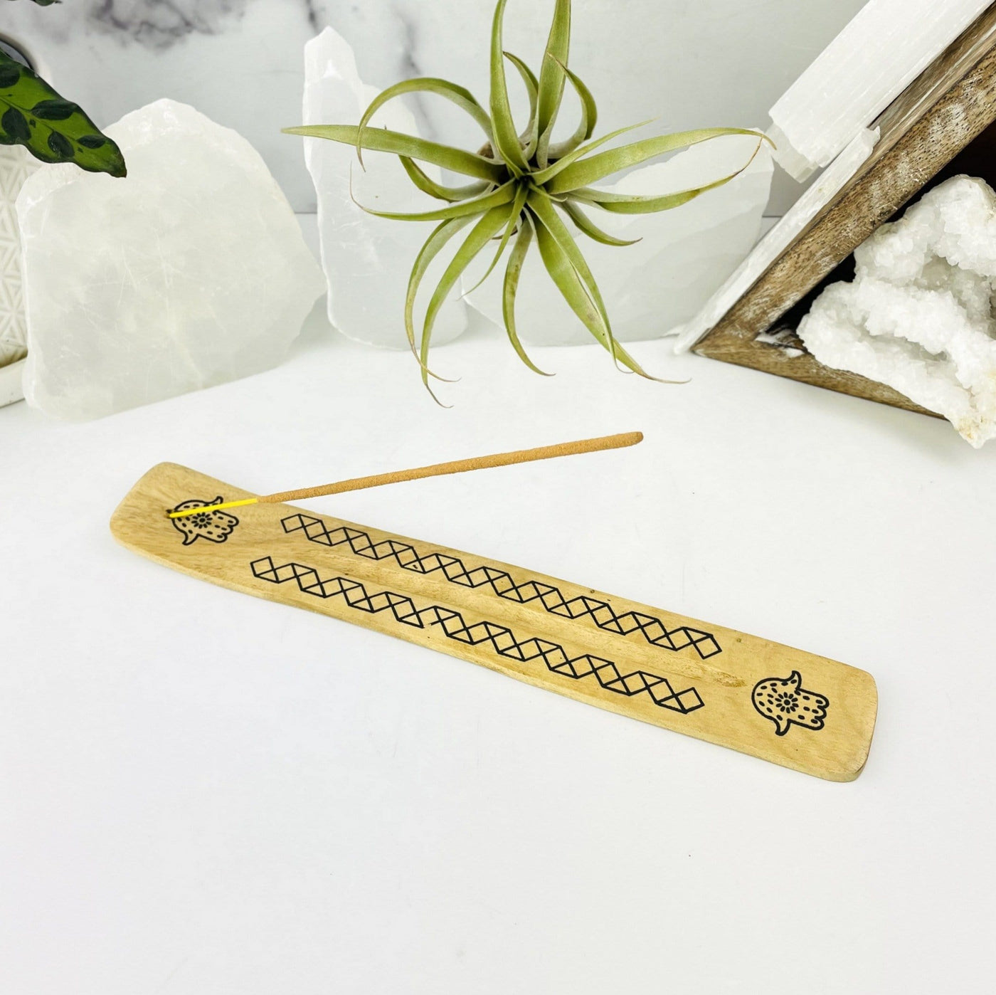 Wooden Incense Burner with Hamsa hand accent on display with an incense in place