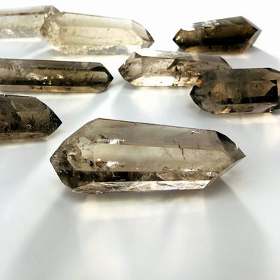 many smokey quartz double points laying on their side on white background for possible variations
