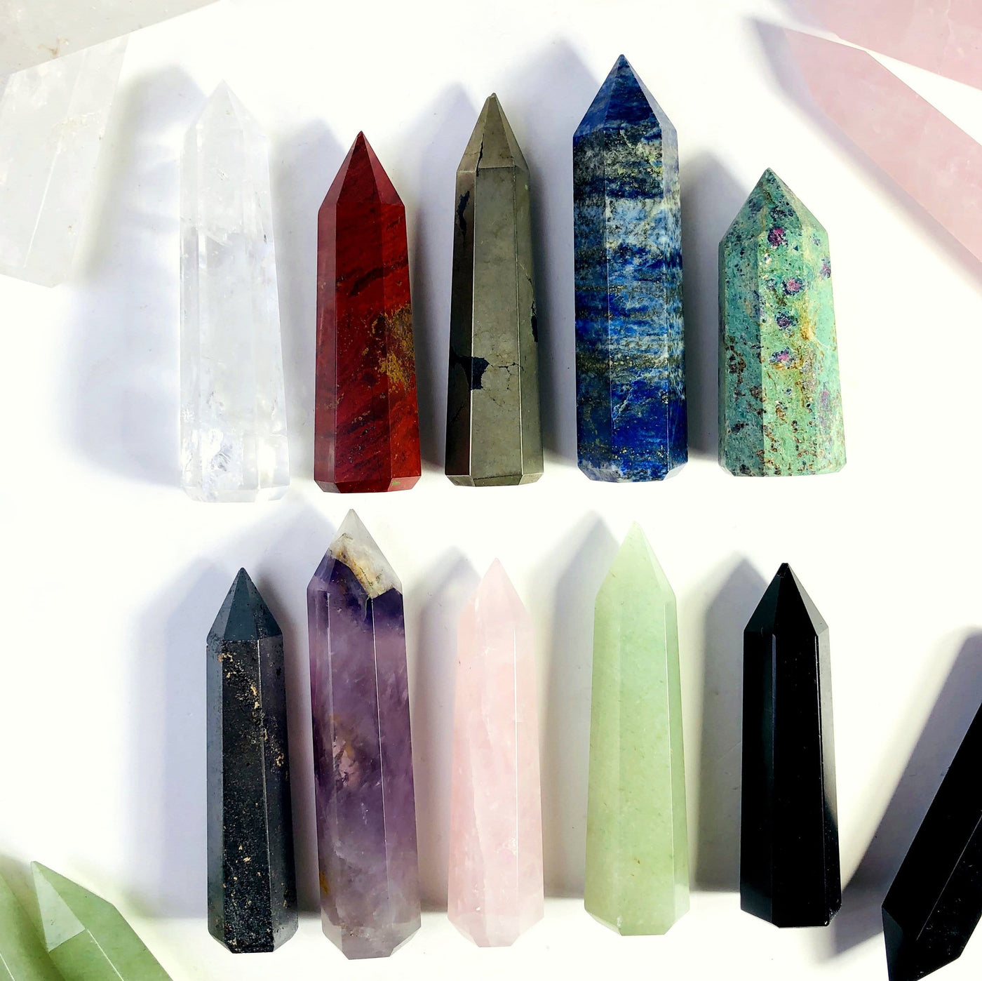 Gemstone Pencil Polished Points displayed on flat surface, one of each color