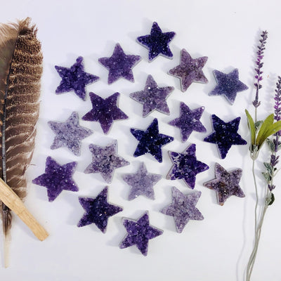 Amethyst Druzy Stars on a table and next to a feather