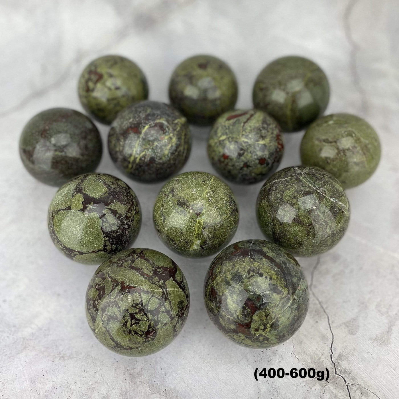 Multiples of Dragon Blood Stone Spheres on Gray Background.