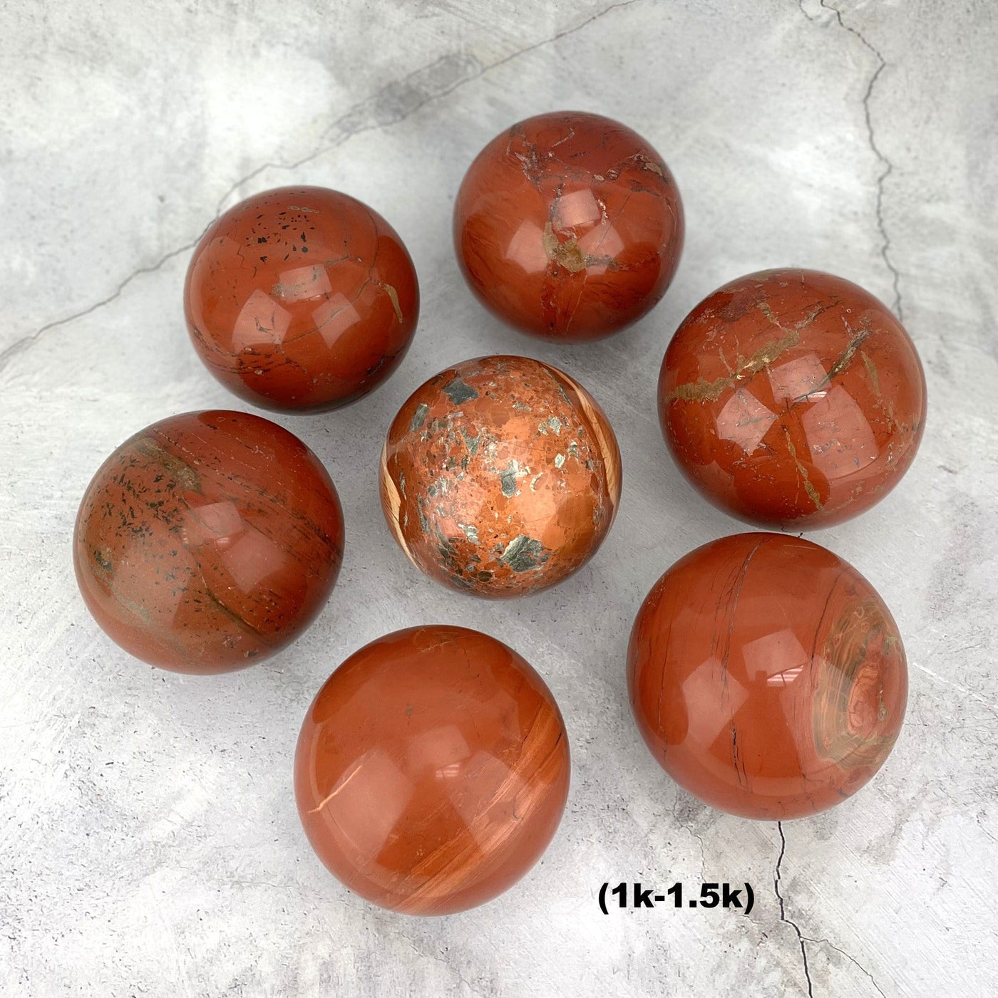 7 1-1.5k Red Jasper Spheres arranged like a flower on gray background