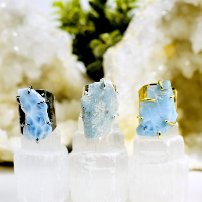 Larimar Rings in oxidized silver, silver, and gold with decorations in the background