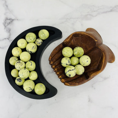 overhead view of 0g-100g serpentine polished spheres in wooden moon bowl and wooden hand bowl for possible variations