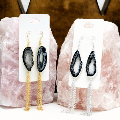 Two pairs of Agate Geode Slice Dangle Earrings displayed on crystals. One pair is silver toned and one pair is gold toned.