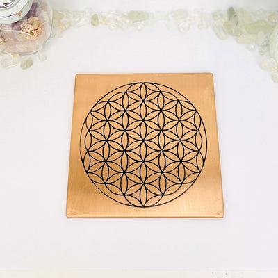 copper square flat plate with a flower of life grid in black on it