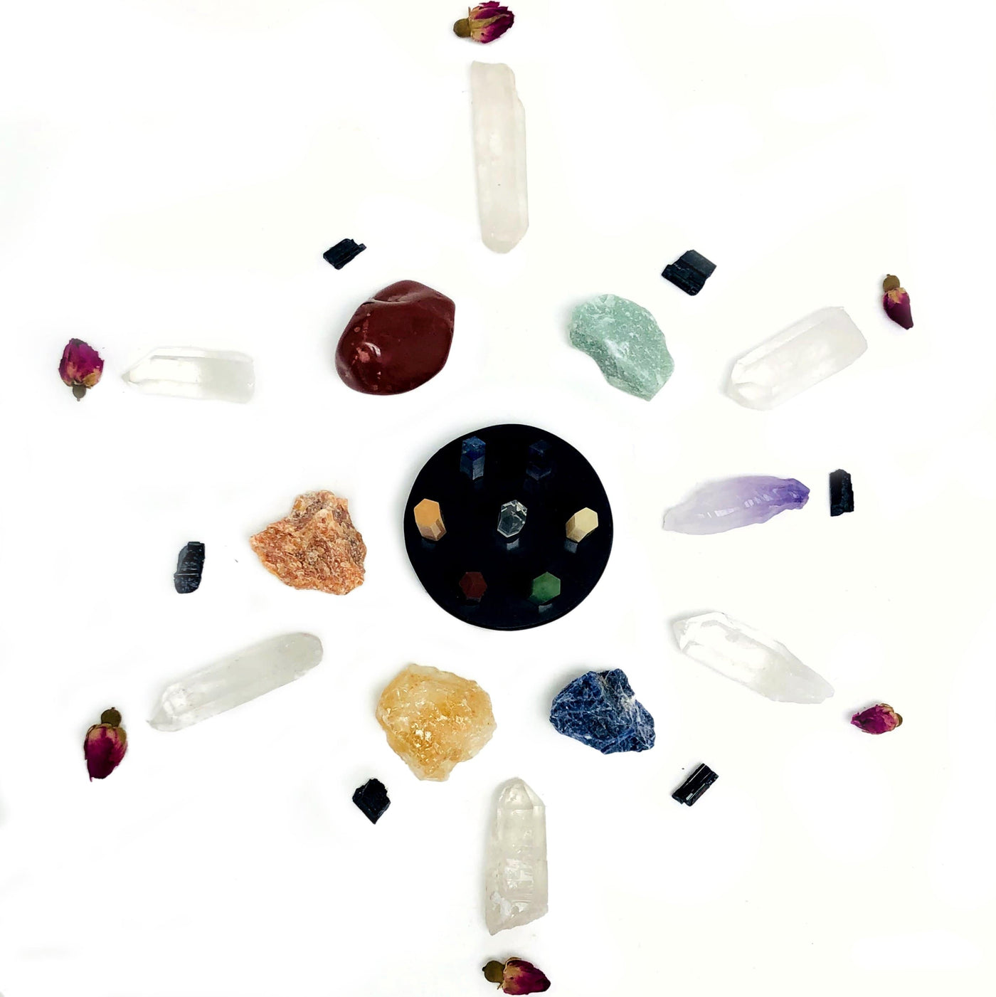 Black obsidian round disk with all seven stone points on it Amethyst, Crystal Quartz, Lapiz Lazuli, Green Aventurine, Peach Aventurine, Yellow Aventurine, and Red Jasper. Overhead view with other crystals scattered for decorative purposes only.