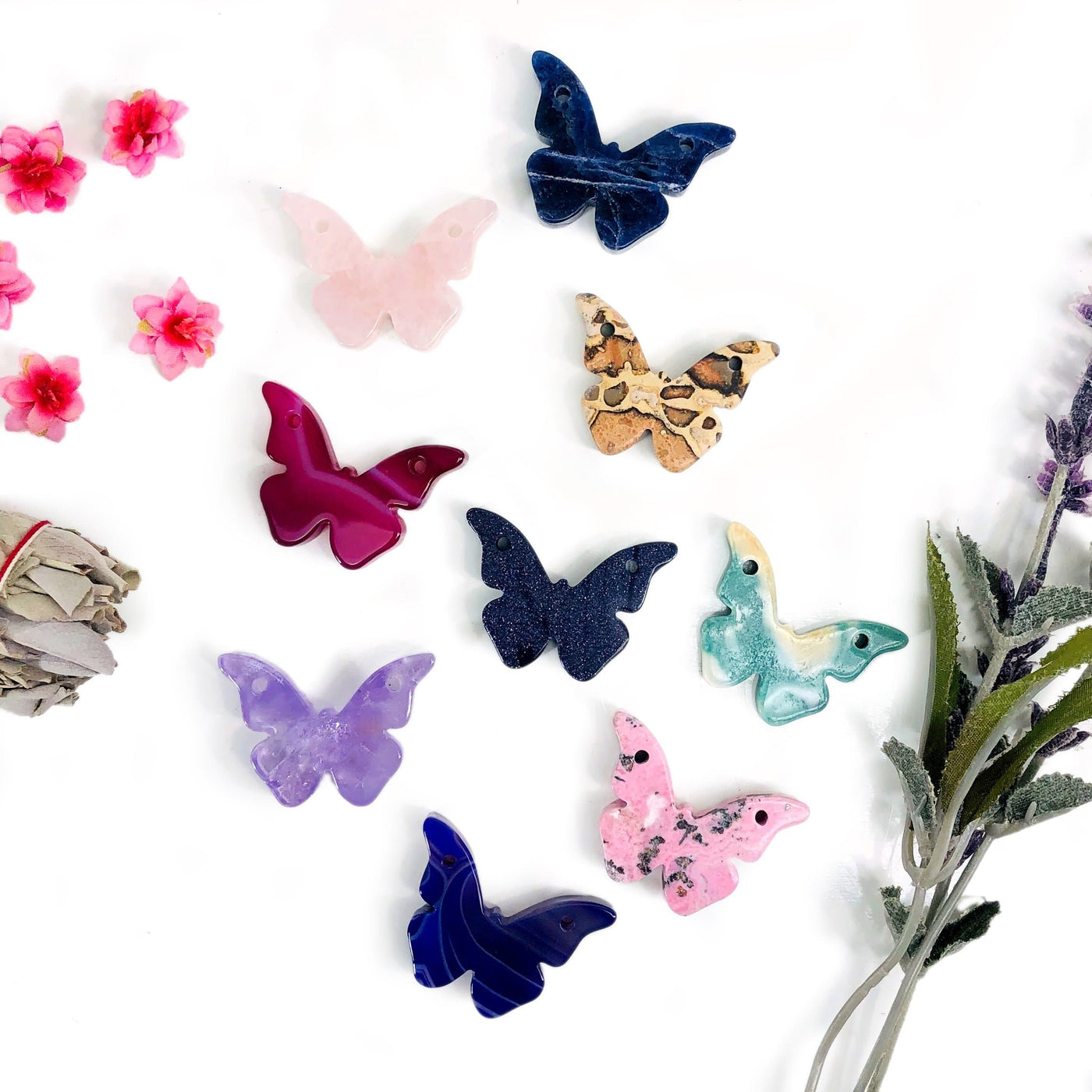 Butterfly Gemstone Double Drilled Stones displayed on white background they come in Blue Goldstone Rose Quartz  Jade Purple Dyed Agate Pink Dyed Agate Jasper Amethyst Sodalite Rhodonite Teal 