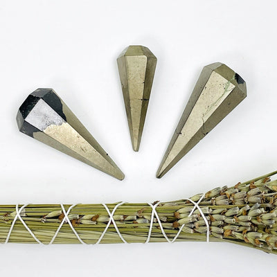pyrite pendulum point with lavender bundle on white background