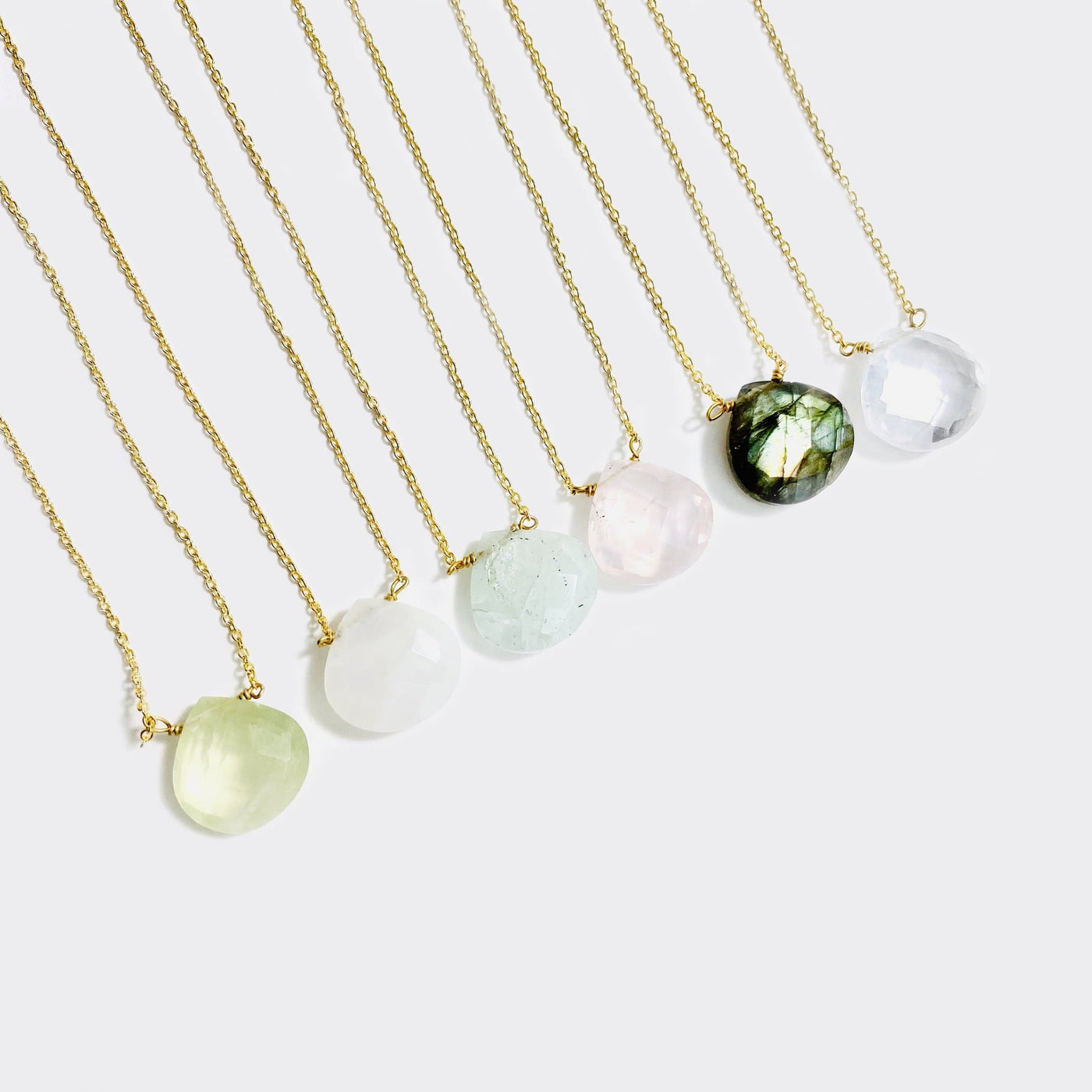 Top view of 6 gemstone drop necklace in gold