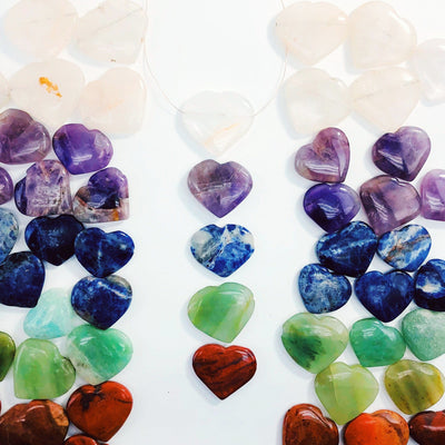 multiple head drilled heart shaped gemstones in a row one with a wire shown as a neckless