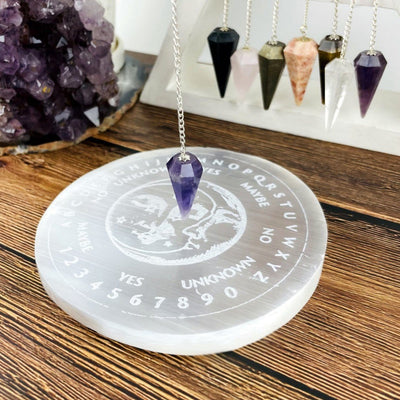 selenite engraved pendulum board on display with pendulum