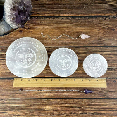 all three selenite engraved pendulum board sizes on display with ruler for size reference