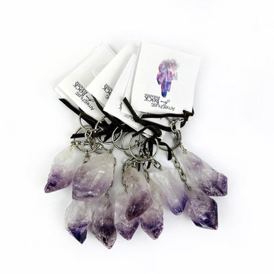 A collection of 10 amethyst crystal Point Keychains with tags tied on them
