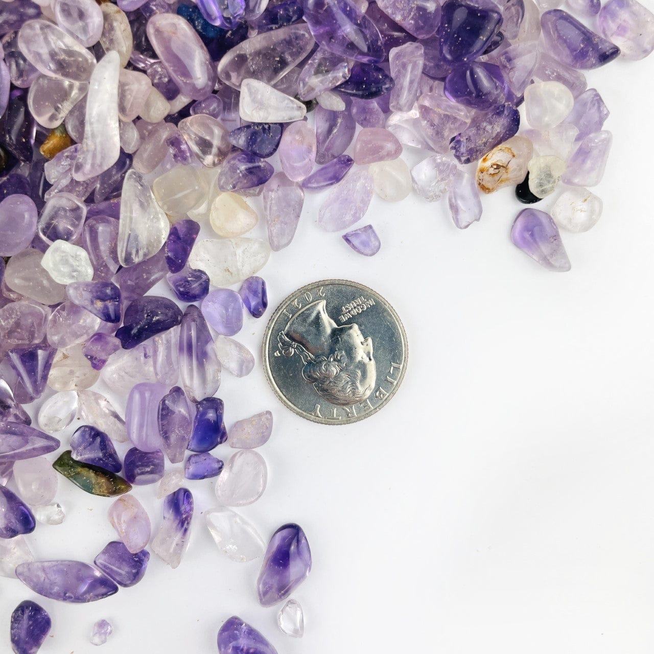  Amethyst Polished Small Chip Stones next to a quarter for size reference