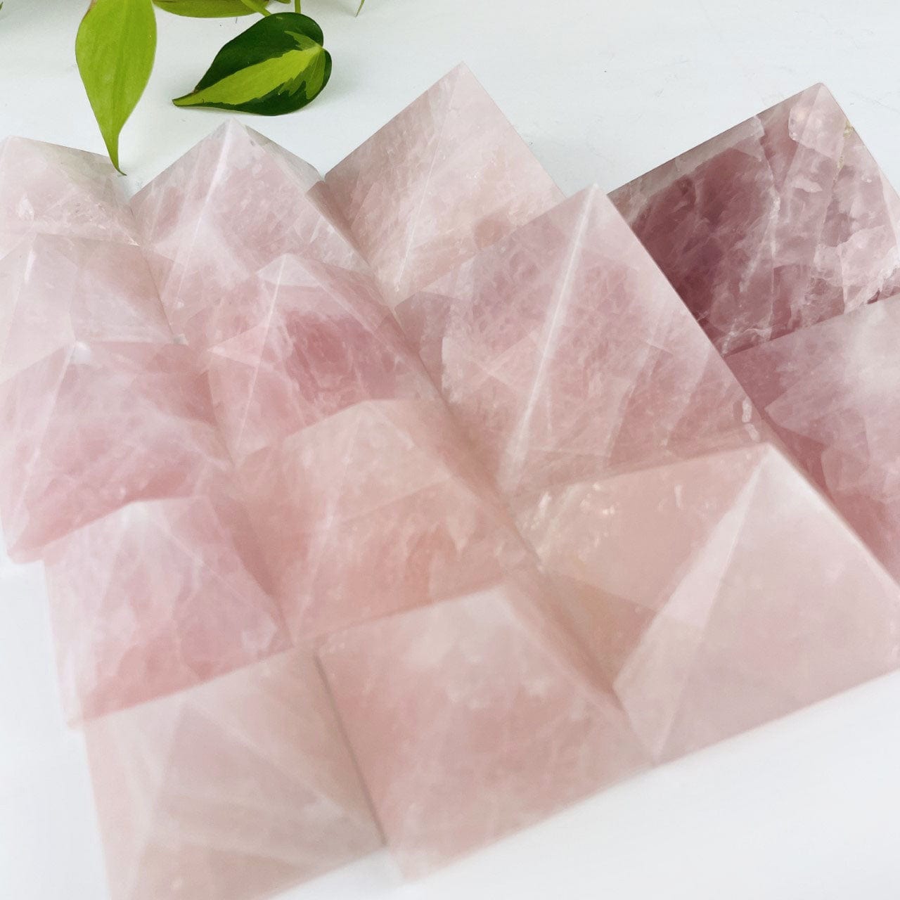 Rose Quartz Pyramids next to each otherin various sizes, showing the shades of rose available in this stock
