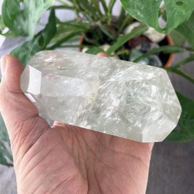Crystal Quartz Polished Stone in a hand showing side view