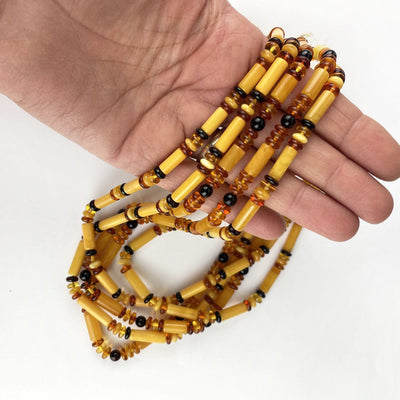 Amber Beaded Necklace with Assorted size and color of Beads in a hand for size reference