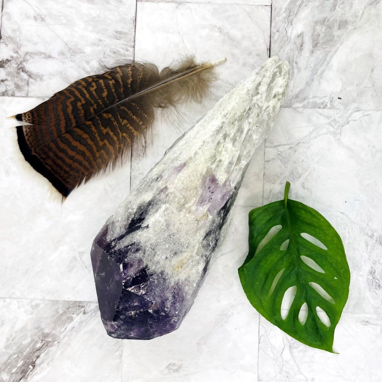 elestial amethyst point on a marble background