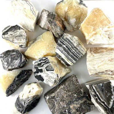 Mexican Onyx Rough Stone Chunks on a table showing different colors and markings of this stock