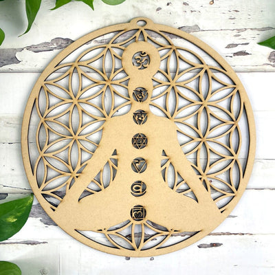 Wood Crystal Grid with Flower of Life Cut outs and a cut out of a person sitting in meditation pose.
