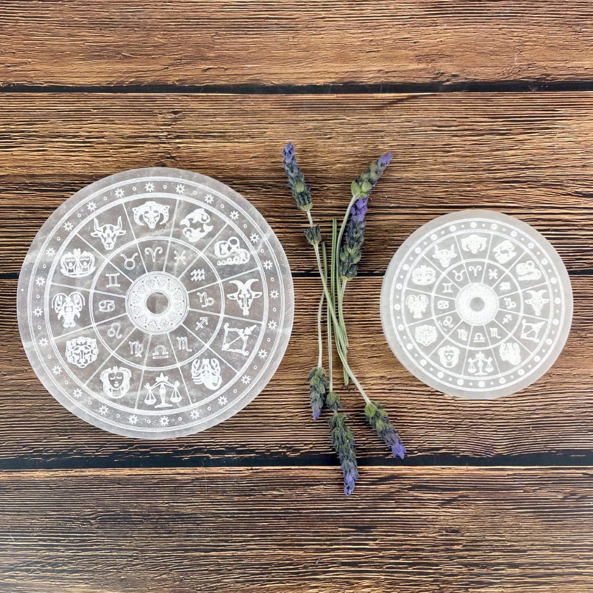 14cm and 10cm selenite zodiac engraved charging plates on display for size comparison 