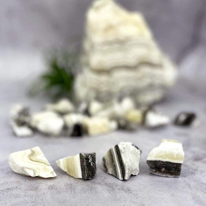 multiple pieces of Mexican onyx rough stones displayed to show various colors patterns shapes between each stone 