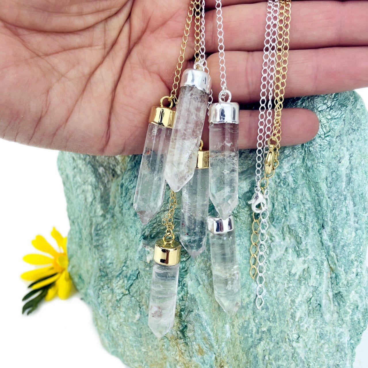 Triple Point Crystal Dangle Pendant Necklace displayed in hand for size reference